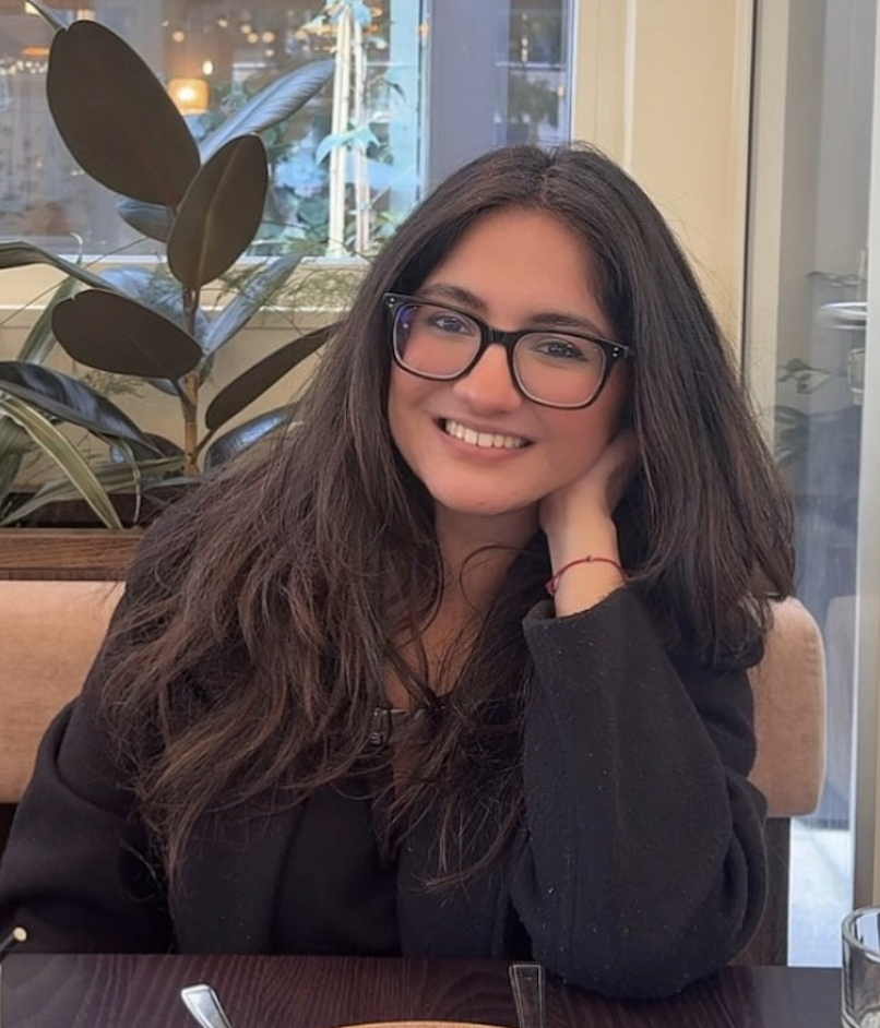 An image of a woman wearing glasses with brown hair in a restaurant