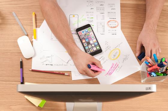 Birdseye view of someone at a messy desk with lots of notes