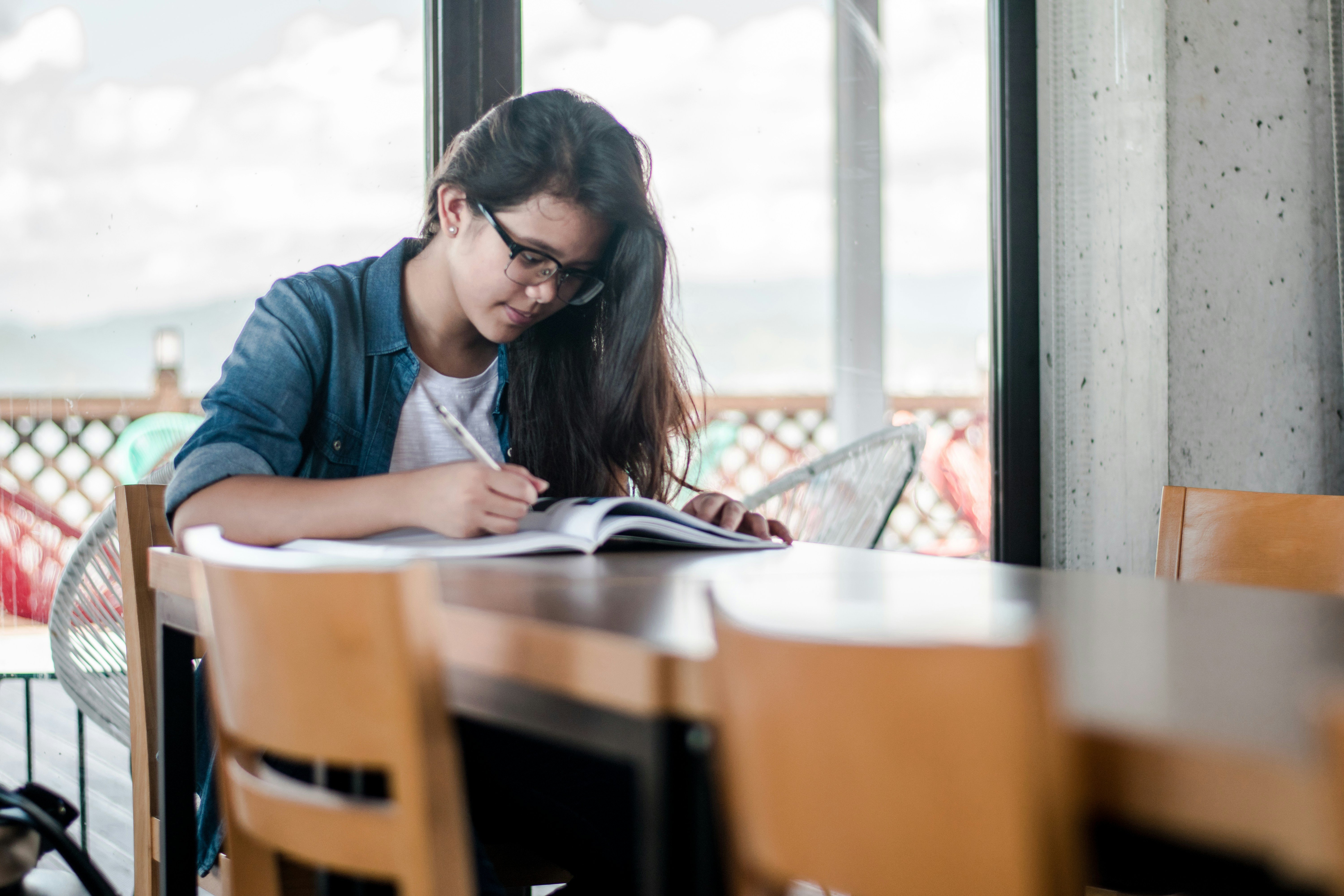 A student learning over a textbook, studying