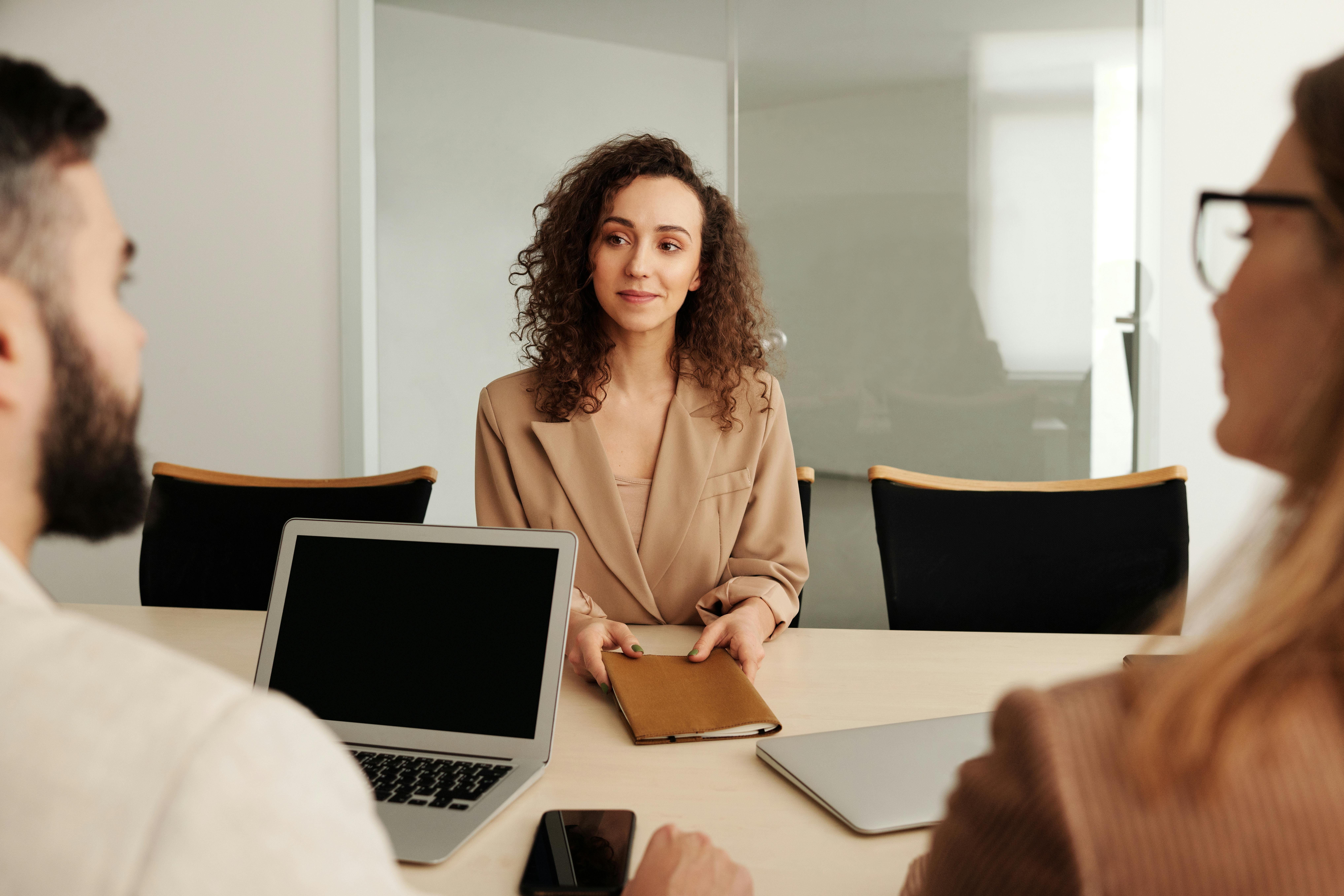 A woman in a job interview, being interviewed by a man and a woman.