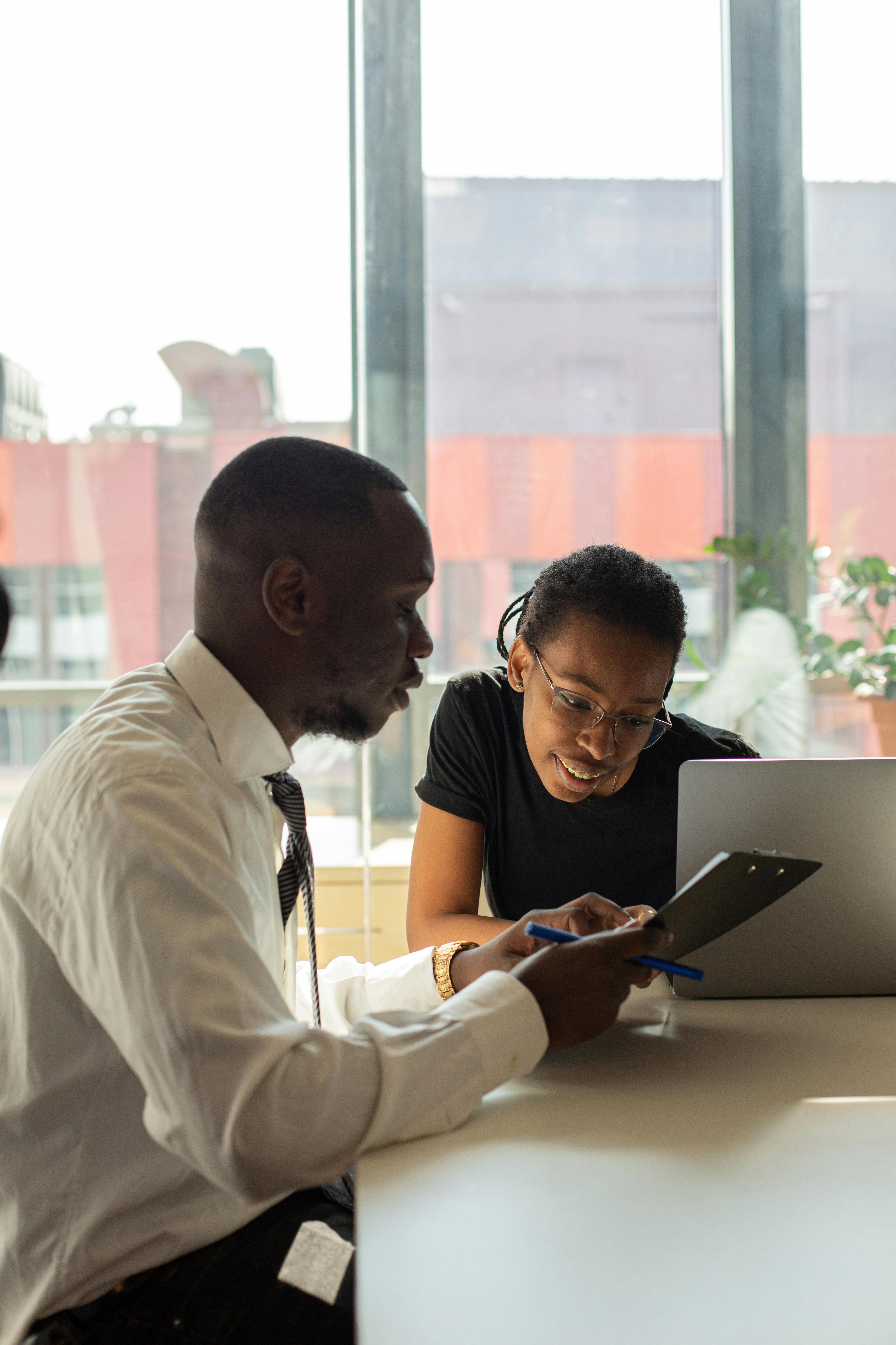 Two people looking at information on a tablet.