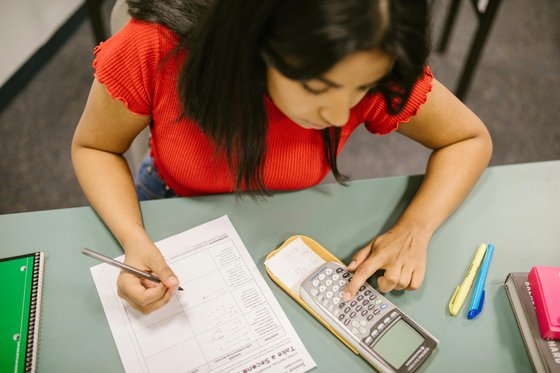 Young woman using a calculator in a maths exam.